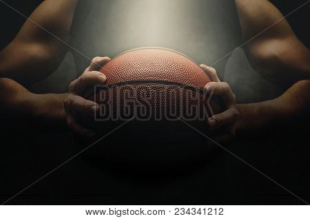 Male Basketball Player With A Ball Over Dark Background. Low Light. Fit Young Man In Sportswear Hold