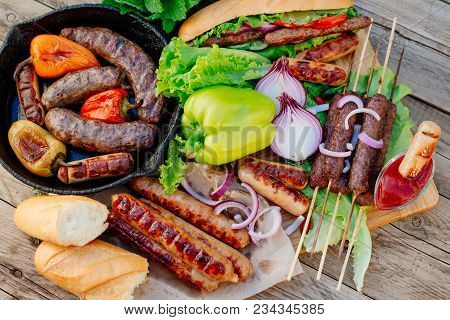 Oktoberfest. Assorted Different Grilled Sausages On A Wooden Table. Fried Sausages On A Cast-iron Fr