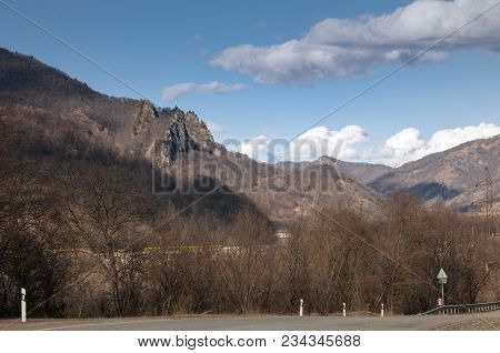 Mountain Slope In The Caucasus Mountains. Trees Without Leaves