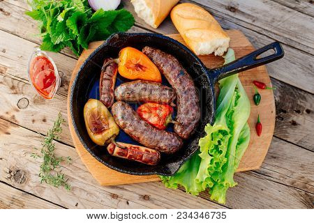 Oktoberfest. Assorted Different Grilled Sausages On A Wooden Table. Fried Sausages On A Cast-iron Fr