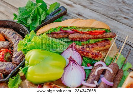 Oktoberfest. Assorted Different Grilled Sausages On A Wooden Table. Fried Sausages On A Cast-iron Fr