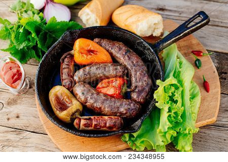 Oktoberfest. Assorted Different Grilled Sausages On A Wooden Table. Fried Sausages On A Cast-iron Fr