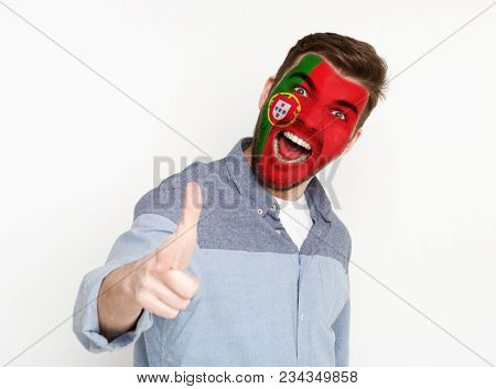 Portrait Of Man With The Flag Of Portugal Painted On His Face. Football Or Soccer Team Fan, Sport Ev