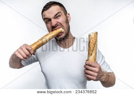 Very Hungry Man Is Starving. He Broke A Long Piece Of Baguette Into Two Pieces. He Is Eating One Of 
