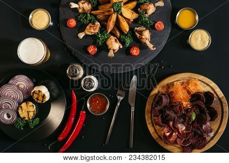 Delicious Assorted Meat With Baked Potatoes, Sauces And Roasted Chicken On Black