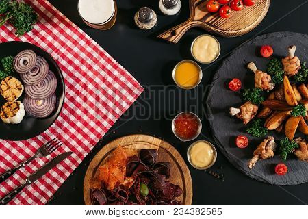 Top View Of Gourmet Assorted Meat, Vegetables, Sauces And Baked Potatoes With Roasted Chicken On Bla