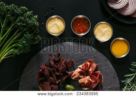 Top View Of Gourmet Craft Meat With Various Sauces On Black