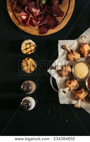 Top View Of Fried Tasty Chicken Wings With Sauces, Spices, Grilled Garlic And Gourmet Assorted Craft