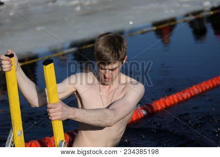 ST. PETERSBURG, RUSSIA - MARCH 4, 2018: Amateur winter swimmer at ice hole during Big Neva Cup. Winter swimmers from 12 countries aged from 12 to 78 take part in the competitions this year