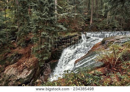 Waterfall In Nature Pine Scandinavian Mountain Forest In Evening Light. Wet Cold Rock Stones Covered
