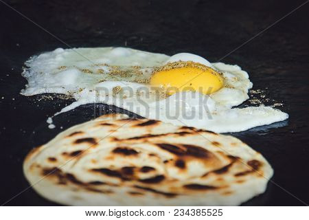 Frying The Dough. Traditional Indian Flatbread Is Fried With Egg. Indian Breakfast. Street Food In I