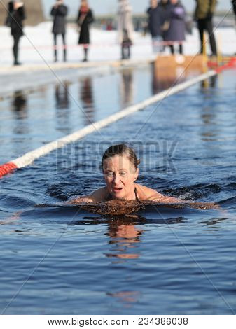 ST. PETERSBURG, RUSSIA - MARCH 4, 2018: Amateur winter swimmer at ice hole during Big Neva Cup. Winter swimmers from 12 countries aged from 12 to 78 take part in the competitions this year