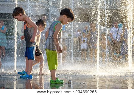 Kyiv, Ukraine August 13, 2017: Happy Kids Have Fun Playing In City Water Fountain On Hot Summer Day.