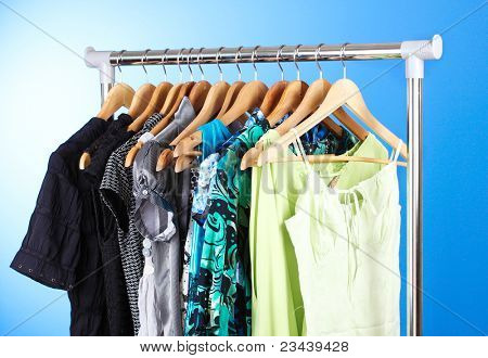 เสื้อผ้าต่าง ๆ บนไม้ hangers บนพื้นหลังสีน้ำเงิน