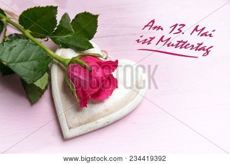 Rose On A Wooden Heart Shape On A Bright Pink Background, German Text Am 13. Mai Ist Muttertag, Mean