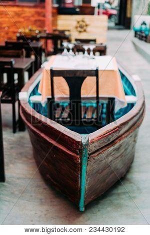 Unusual Restaurant Interior: Dining Table In The Colorful Fish Boat. Marine Ambience.