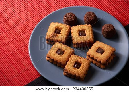 Chocolate Cookies On Gray Plate On Red And Black Table