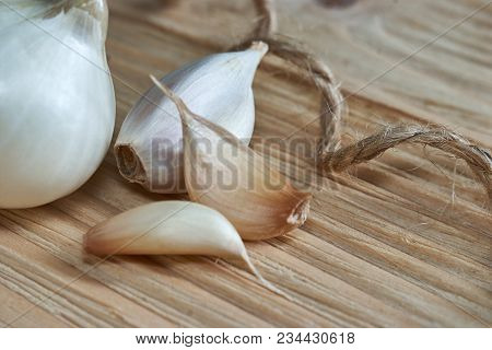 Onion, Garlic, Black Pepper And Bay Leaf On A Wooden Table