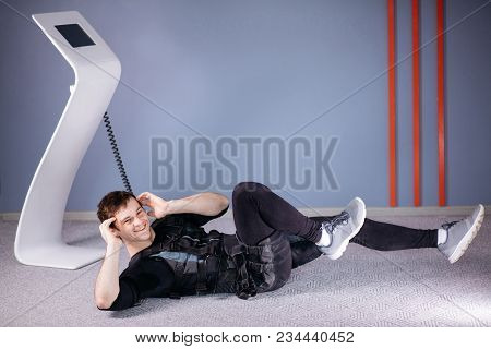 Male Athlete Wearing Ems Suit Doing Abs Exercise Or Sit Ups