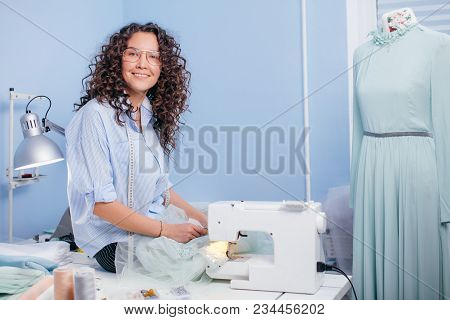 Cherrful Seamstress Sitting On The Desk With Scissors Indoors. Going To Cut. Ready To Cut.