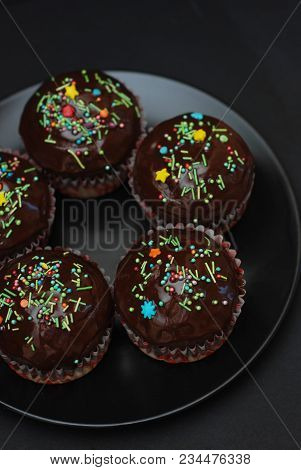 Homebaked Chocolate Muffins For Easter With Colored Conffeti. Dark Background. Sweet Dessert