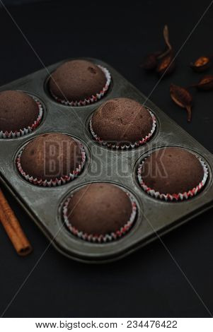 Just Baked Homebaked Chocolate Muffins For Dessert With Colored Conffeti. Black Background.