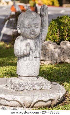 Hacienda Heights, Ca, Usa - March 23, 2018: Closeup Of Boy Novice Monk Cement Statue In Garden Of Hs