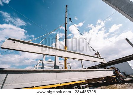 Industrial Heavy Duty Crane Lifting Precast Cement Beams And Pillars On Construction Site