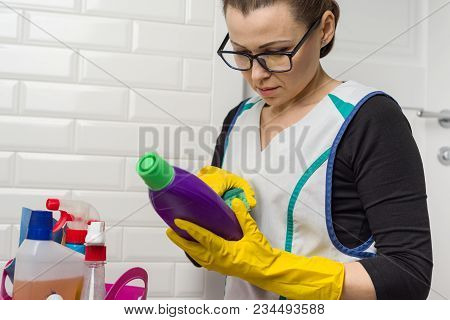 Housewife Woman Does The Cleaning With Interest Reading The Instructions On The Detergent.