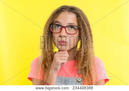 Pretty Girl 12-13 Years Old Blonde With Curly Hair With Glasses, Looks Pensively Aside, Thinking Abo