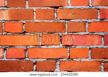 Red briks wall. New brick wall texture. The crumbling wall of bricks. Wall texture background. The plaster on the wall. Uneven wall surface. The paint on the wall. Plastered walls. Abstract background. Painted brick wall