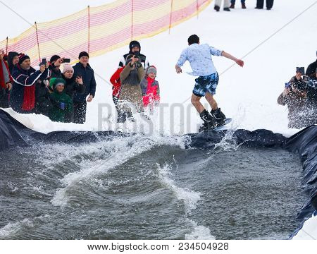 Lipetsk, Russia - March 31, 2018: A Man Snowboarding From Mountain To Water.