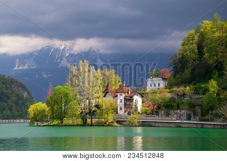 Scenic View Of Lake Bled - Popular Tourist Attraction In Julian Alps - With Quay In Sunlit And Mount