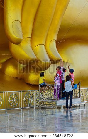 Angthong, Thailand - June 9, 2013 Buddhists Touching End Of Finger Of Large Golden Buddha Image With