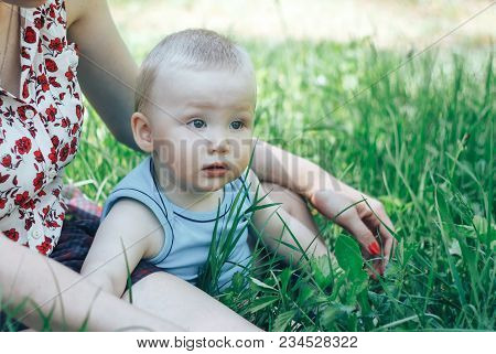 Little Nine Month Old Baby Sitting In The Park In Beautiful Evening