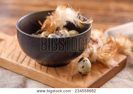 Quail Eggs In Ceramic Mug, Napkin, Wooden Board On Wooden Table. Quail Eggs Similar In Color With A 