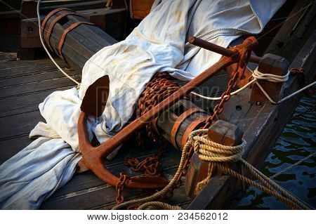Close Up Macro Of Weathered And Aged Industrial Rusted Anchor Buried In A Wooden Ship