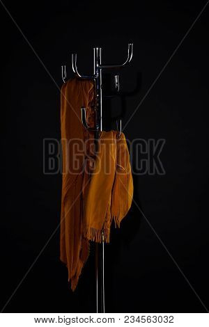 Yellow Scarves On Coat Rack Isolated On Black