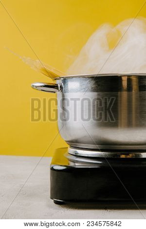 Close-up Shot Of Delicious Spaghetti Boiling In Stewpot On Yellow