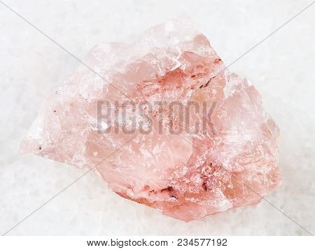 Macro Shooting Of Natural Mineral Rock Specimen - Crystal Of Rose Quartz Gemstone On White Marble Ba
