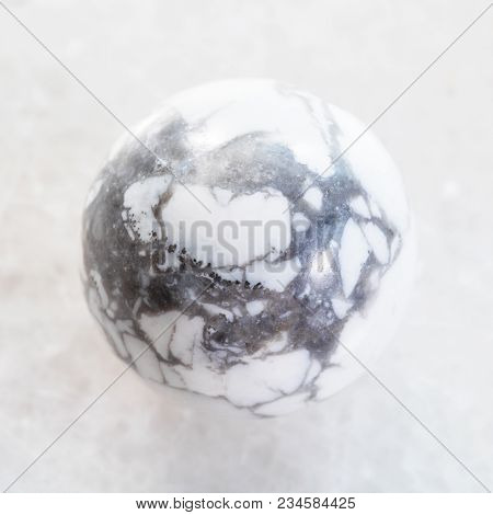 Macro Shooting Of Natural Mineral Rock Specimen - Bead From Howlite Gemstone On White Marble Backgro