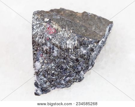 Macro Shooting Of Natural Mineral Rock Specimen - Rough Antimonite Stone On White Marble Background 