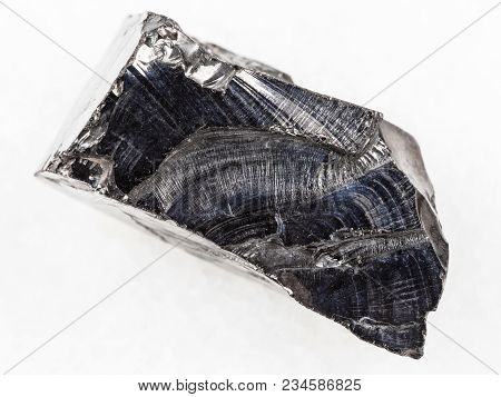 Macro Shooting Of Natural Mineral Rock Specimen - Raw Shungite Stone On White Marble Background From