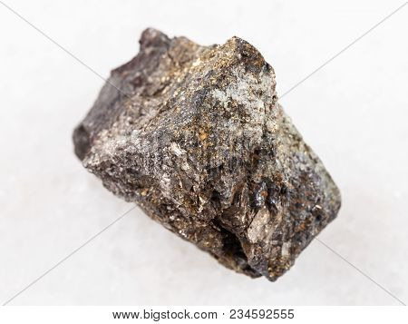 Macro Shooting Of Natural Mineral Rock Specimen - Rough Arsenopyrite Stone On White Marble Backgroun