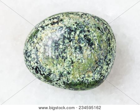Macro Shooting Of Natural Mineral Rock Specimen - Tumbled Serpentine Gemstone On White Marble Backgr