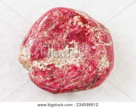 Macro Shooting Of Natural Mineral Rock Specimen - Polished Thulite Gemstone On White Marble Backgrou