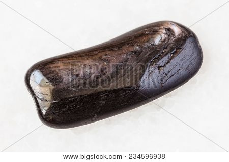Macro Shooting Of Natural Mineral Rock Specimen - Tumbled Hypersthene Gemstone On White Marble Backg