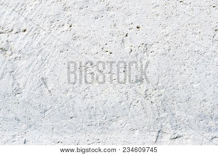 Close-up Deep Texture Of White-painted Porous Stone On The Facade Of The Building. Stoned Wall Backg
