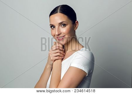 Sexy Young Girl In A White T-shirt And His Gelled Hair In A Ponytail Standing On White Background