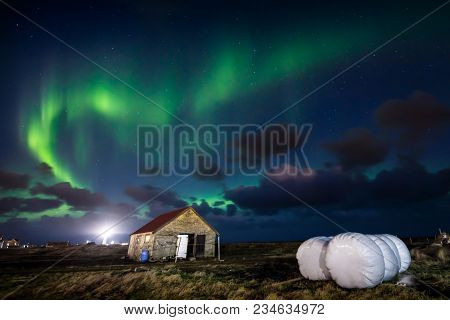 Northern Lights (aurora Borealis) Over Farm House In Gardur Town, Reykjanes Peninsular